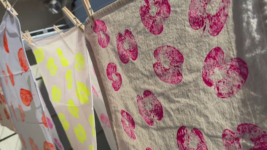 short video of handprinted textiles hanging on line in sun, blowing gently in the breeze 